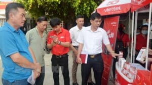 Bí thư Huyện ủy Giồng Trôm Nguyễn Thái Bình xem các dòng máy điện thoại của Viettel hỗ trợ giá cho khách hàng.